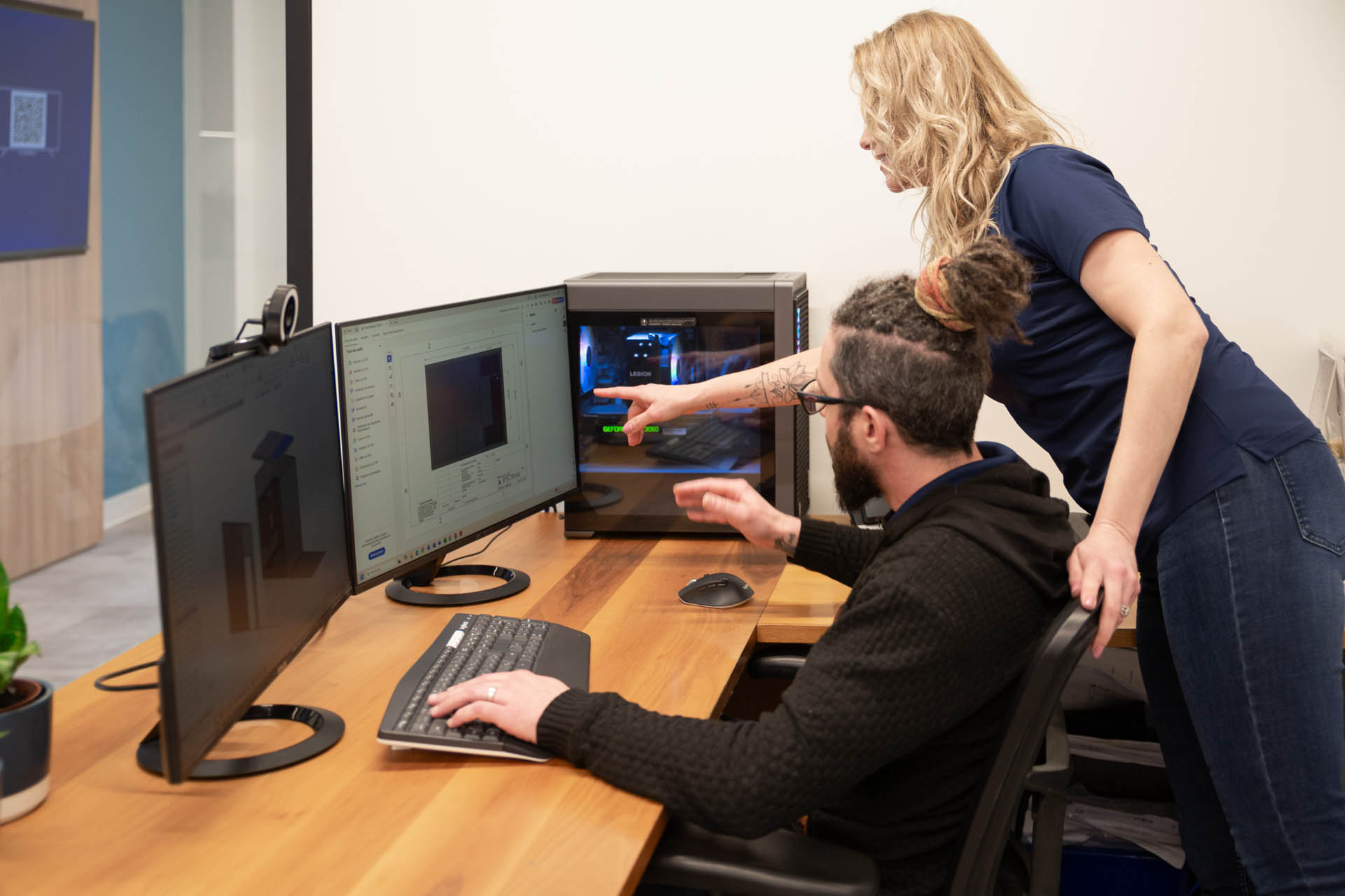 Two colleagues collaborating on a project in front of computers.