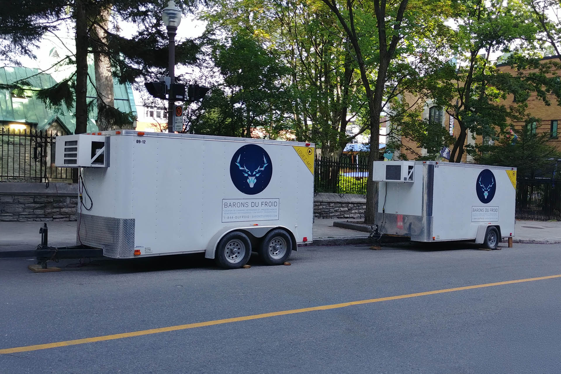 Two Barons du Froid refrigerated trailers parked on the side of a street